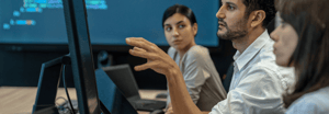 Three people looking at a computer monitor