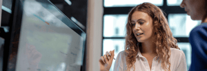 A young woman interacting with a screen displaying data