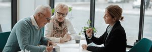 Two older customers speaking with a wealth management advisor