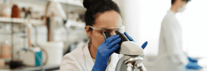 A female scientist looking through a microscope