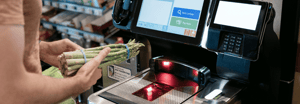 A shopper using self checkout to purchase groceries