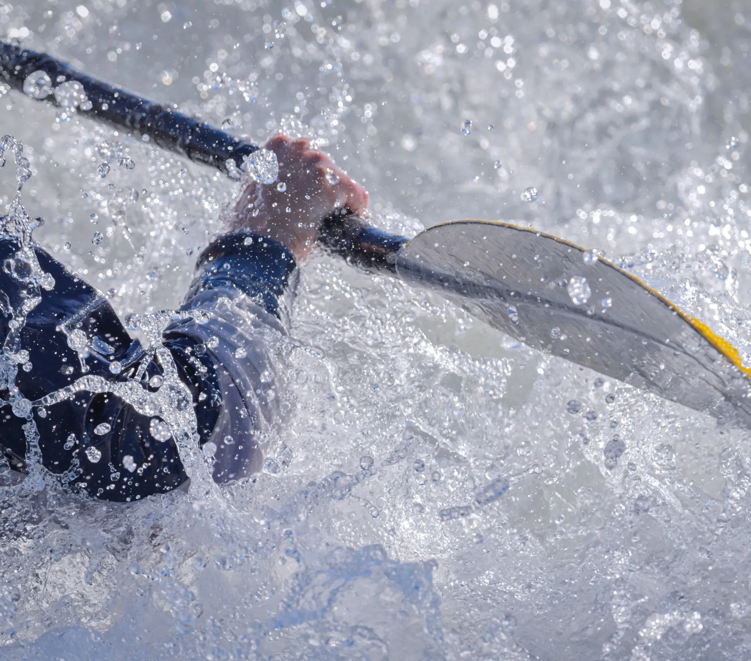 Kayaker paddling through white water